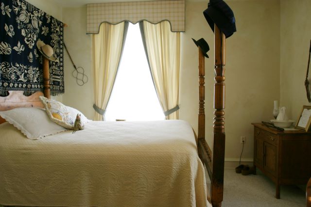 a bedroom with a bed and a hat on the window